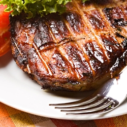 Grilled pork meat on plate with green salad